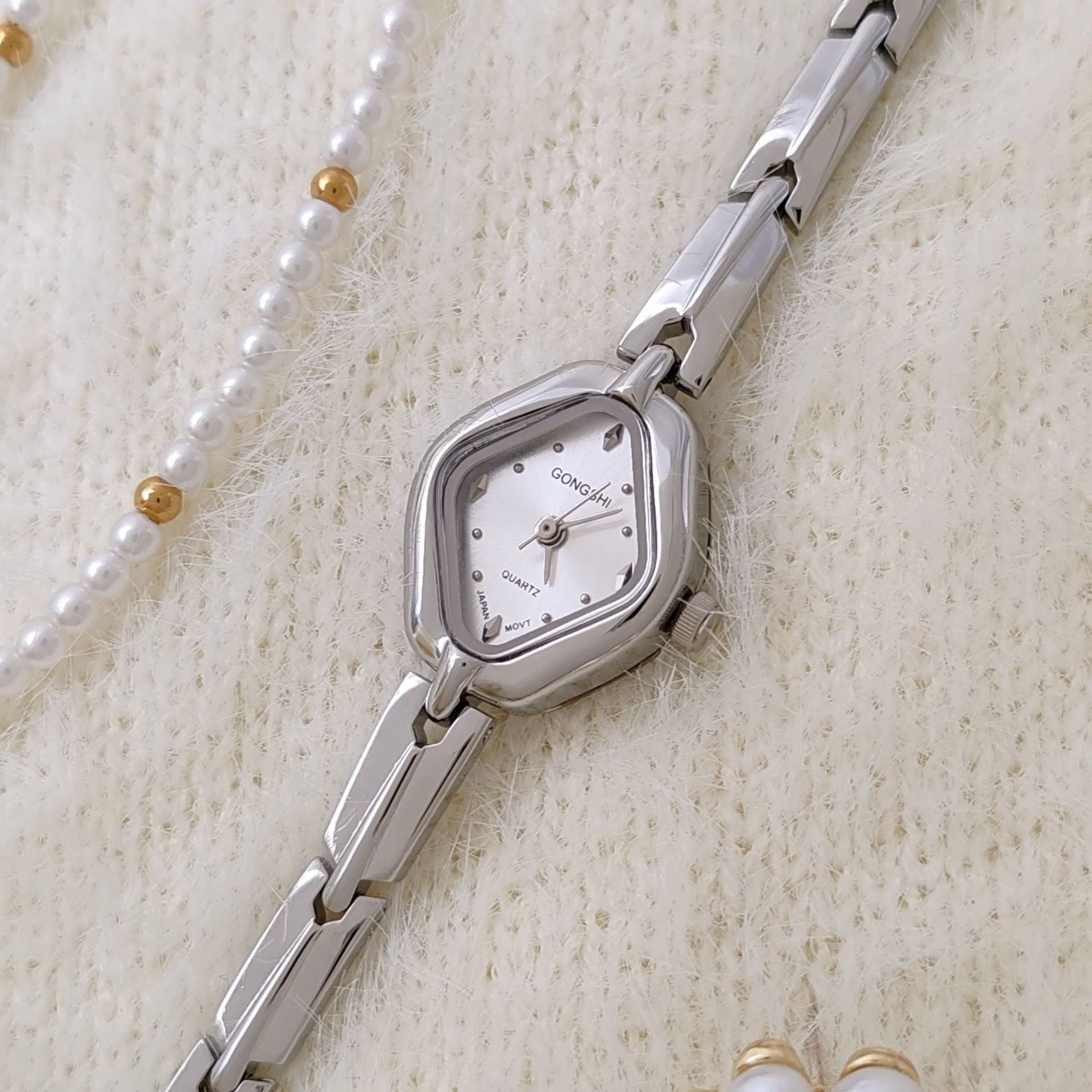 Ladies diamond fashion watch with gold or silver finish and chain strap, showing 7mm thickness and mineral glass face