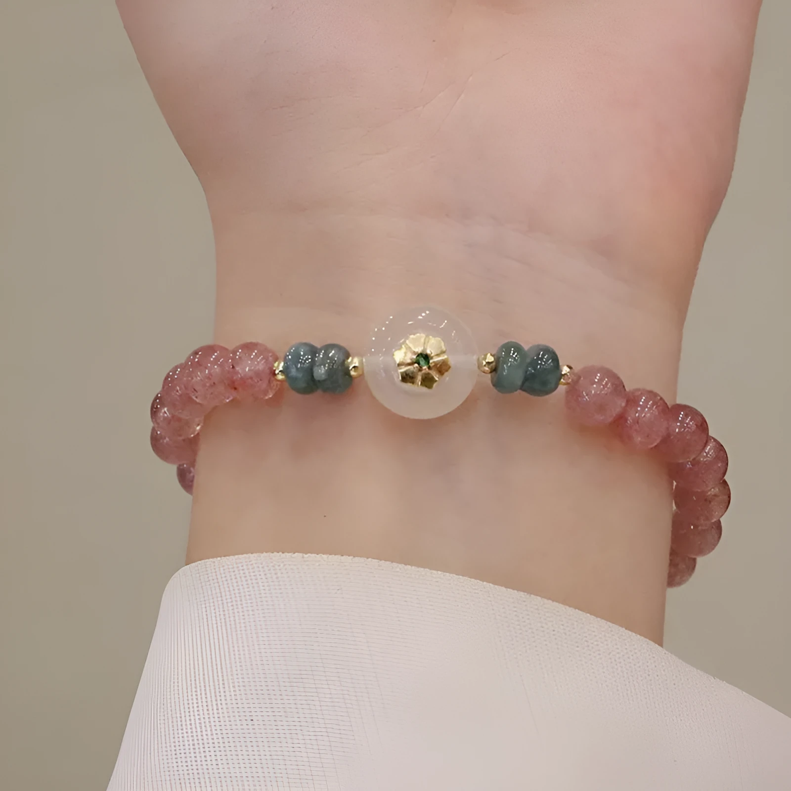 Women's strawberry quartz bracelet with blue water emerald jade pendant, geometric shapes, and traditional Chinese symbolism