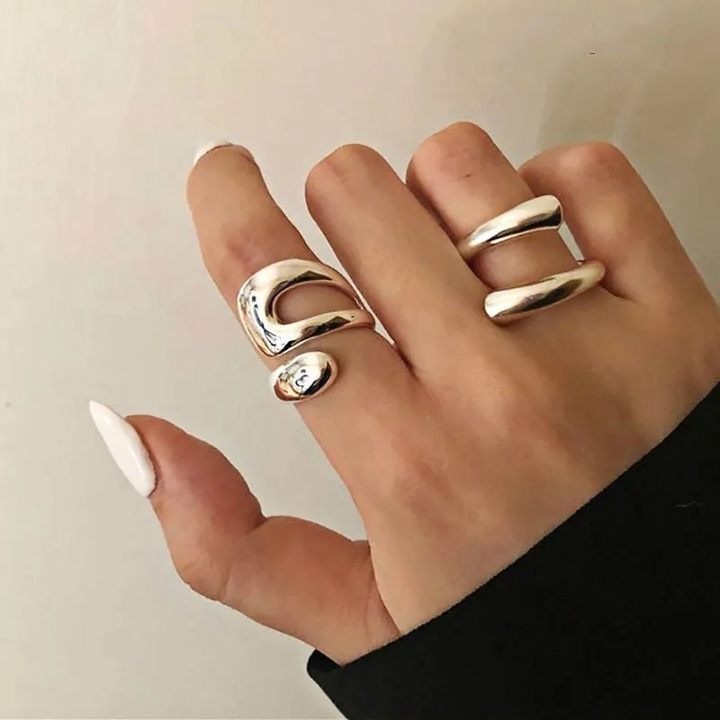 Silver tone adjustable geometric open ring with heart motif on a white background