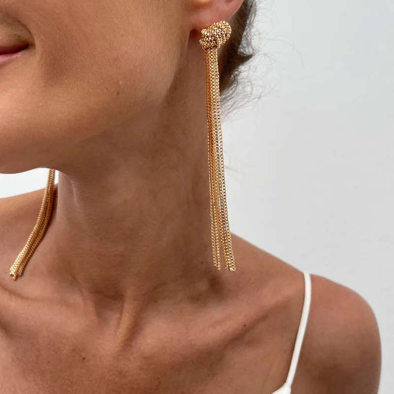 Simple Y-shaped metal tassel necklace set with gold finish and matching earrings on white background