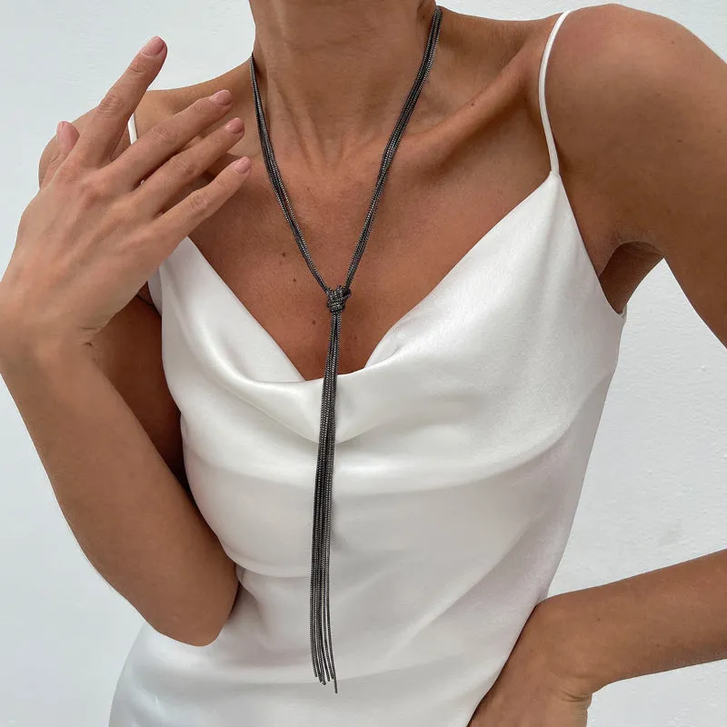 Simple Y-shaped metal tassel necklace set with gold finish and matching earrings on white background