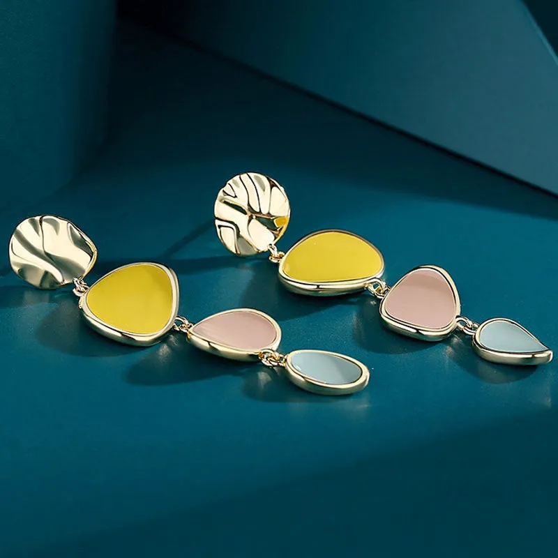 A pair of simple disc-shaped earrings with a morandi three-colour oil-drip finish and sterling silver posts.