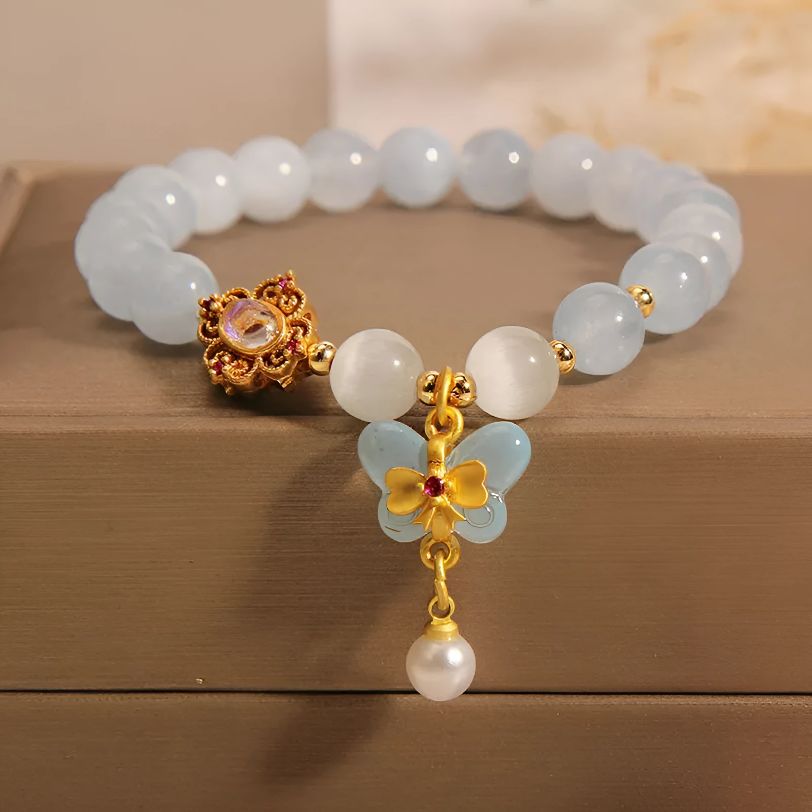Aquamarine butterfly pendant crystal bracelet for women with rhinestone details on silver chain.