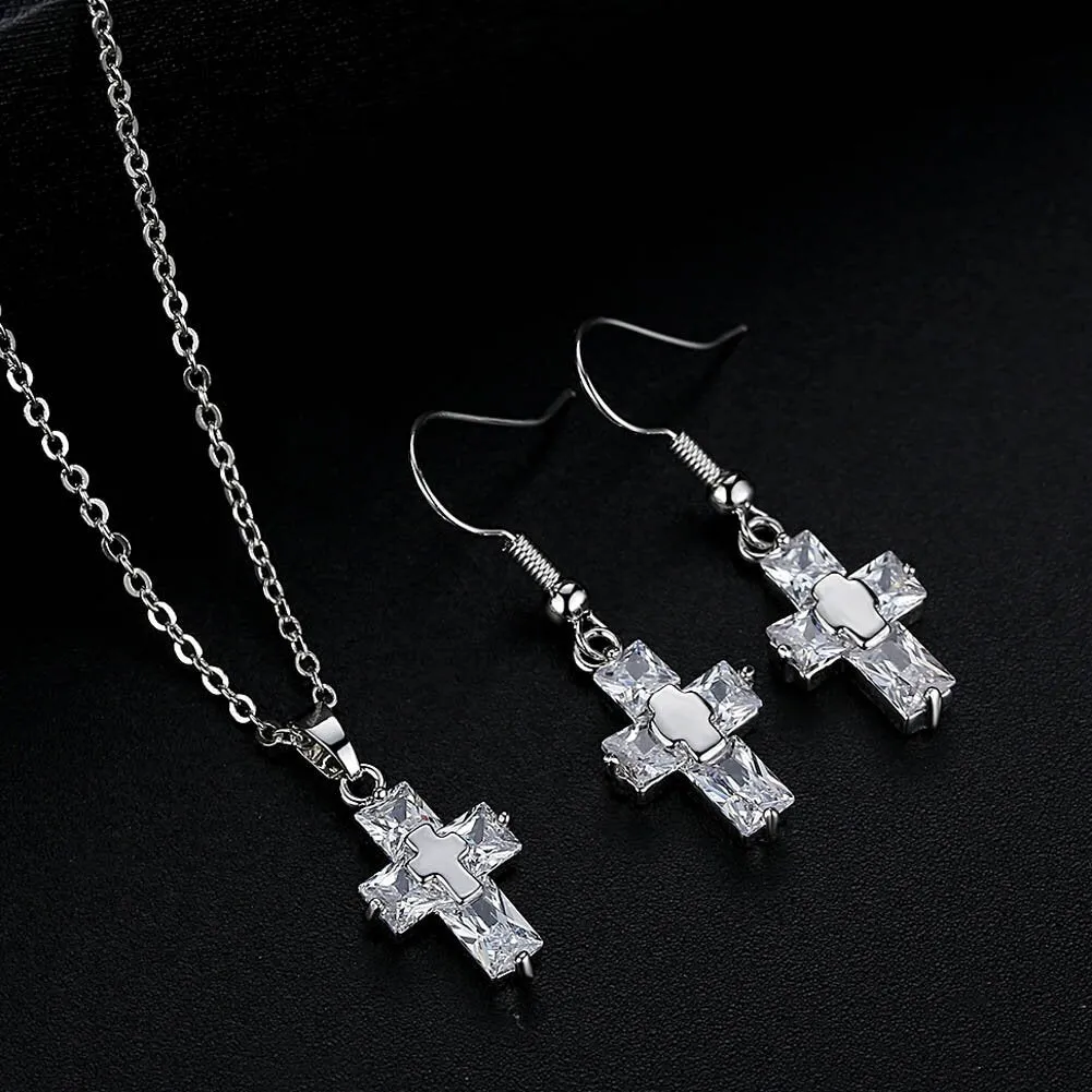 Gold cross pendant and matching stud earrings set on a light background showing compact 1.2 x 2.2 cm pendant and 3.3 x 1.2 cm studs