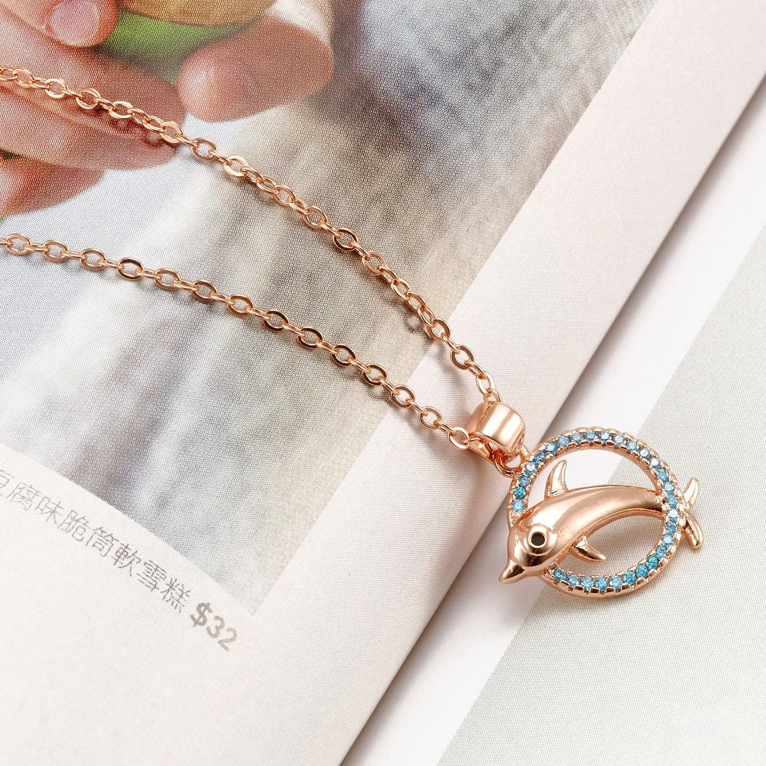Romantic copper dolphin pendant necklace in rose gold on white background