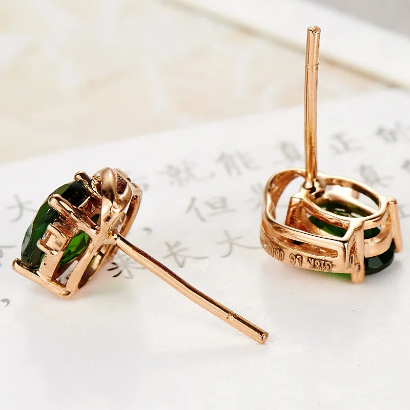 Pair of green ghost crystal stud earrings in silver with diamond-cut geometric shape on white background