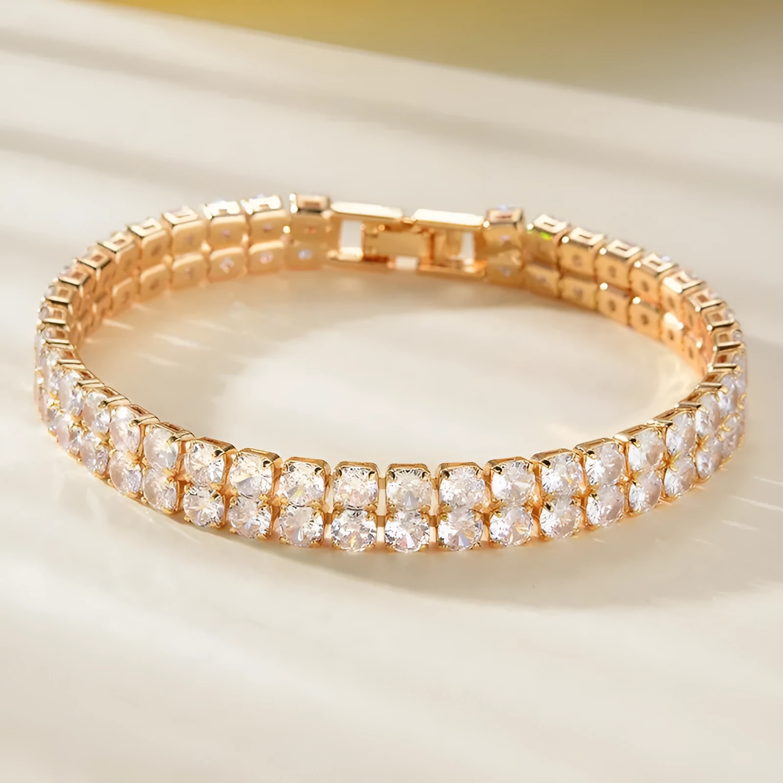 Unisex gold electroplated double-row diamond zirconia tennis chain bracelet on white background
