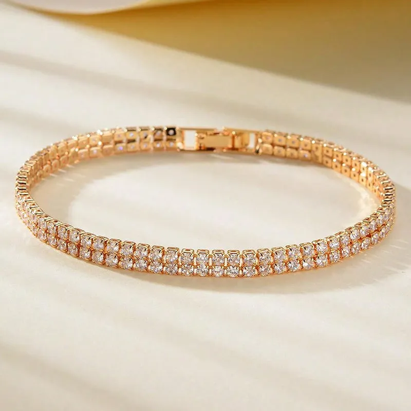 Unisex gold electroplated double-row diamond zirconia tennis chain bracelet on white background