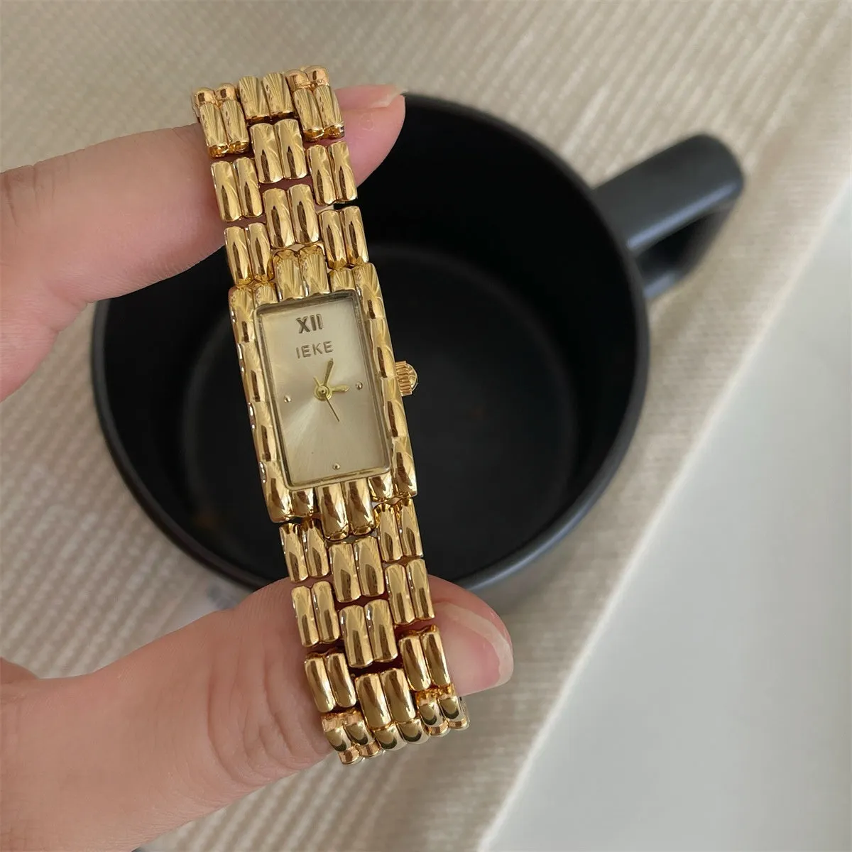 Mid-ancient style women's watch with butterfly buckle on wrist, showing gold and silver strap options