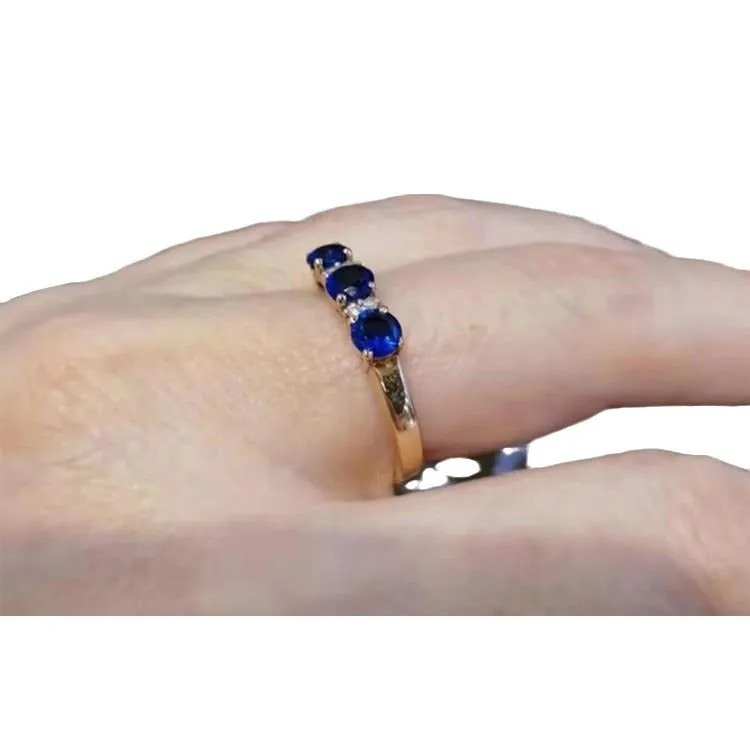 Women's geometric copper electroplated ring with adjustable opening and inlaid blue stone on a neutral background