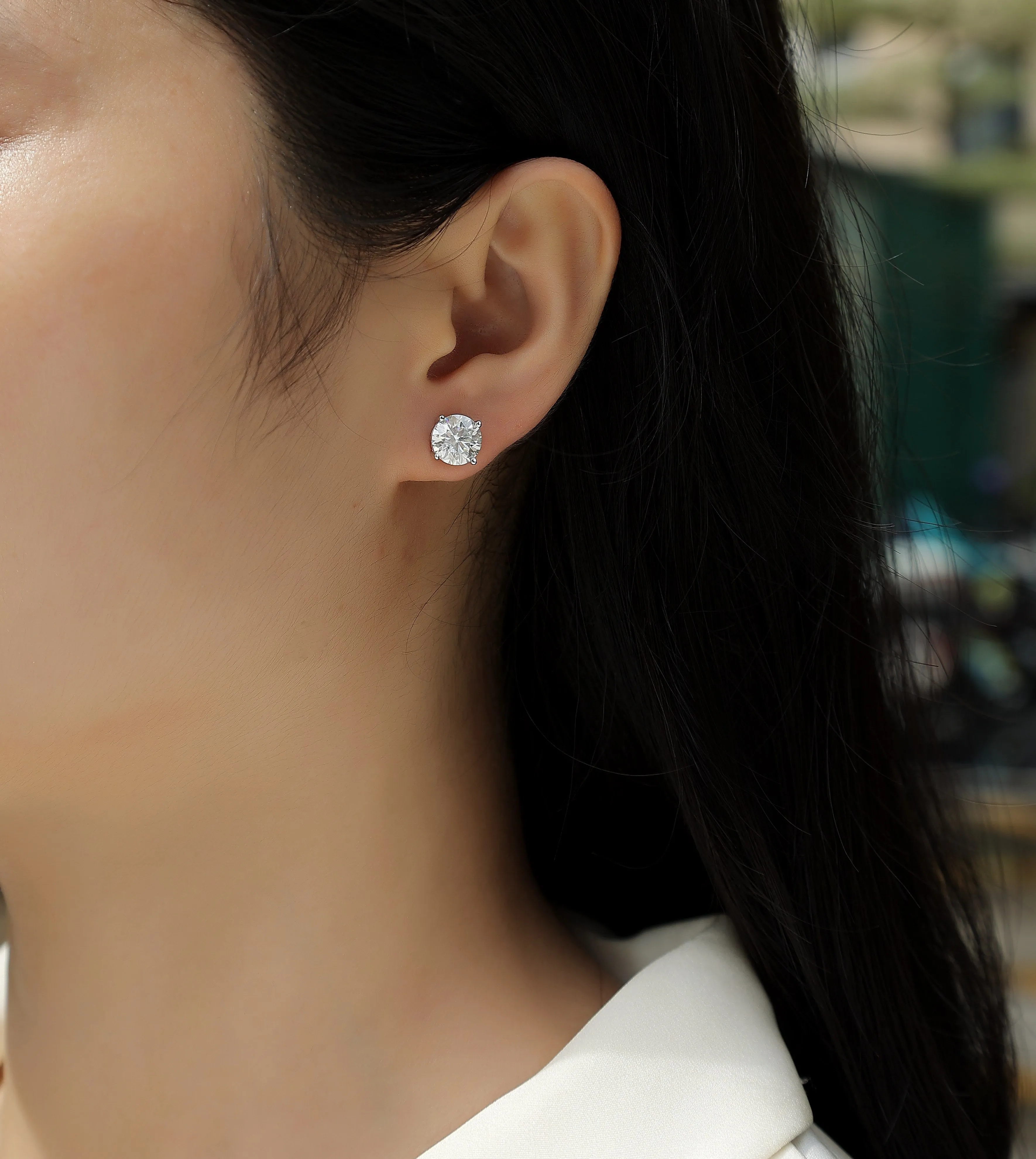 Pair of moissanite stud earrings with platinum-plated S925 silver settings, on a gift box, available in black or transparent stones