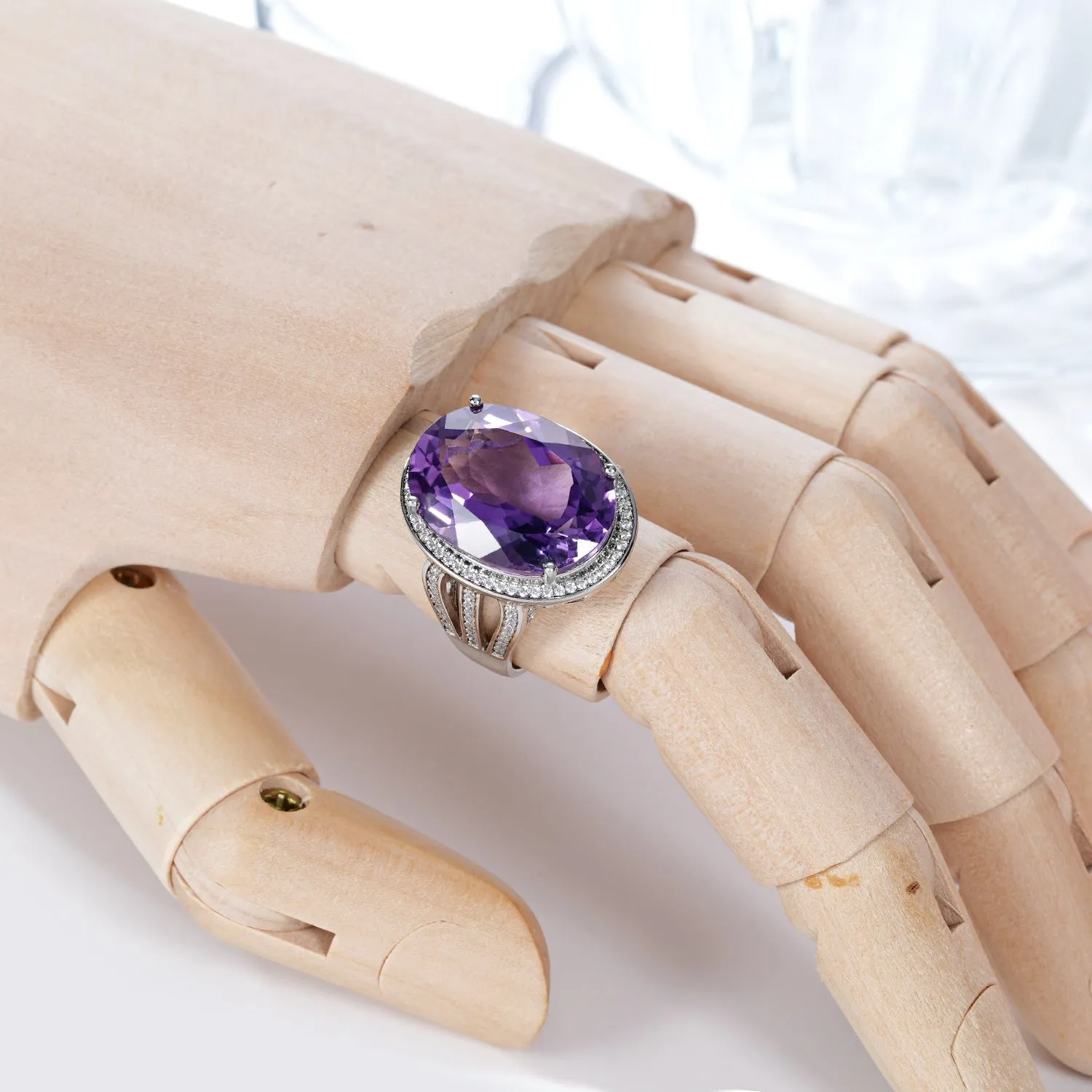 Natural amethyst ring in 925 silver with oval 19-carat stone, white finish, side view on finger