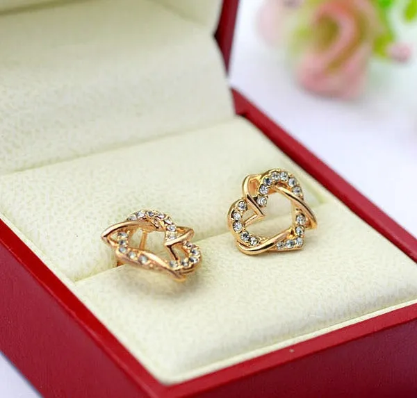Gold colour alloy heart-shaped stud earrings on white background