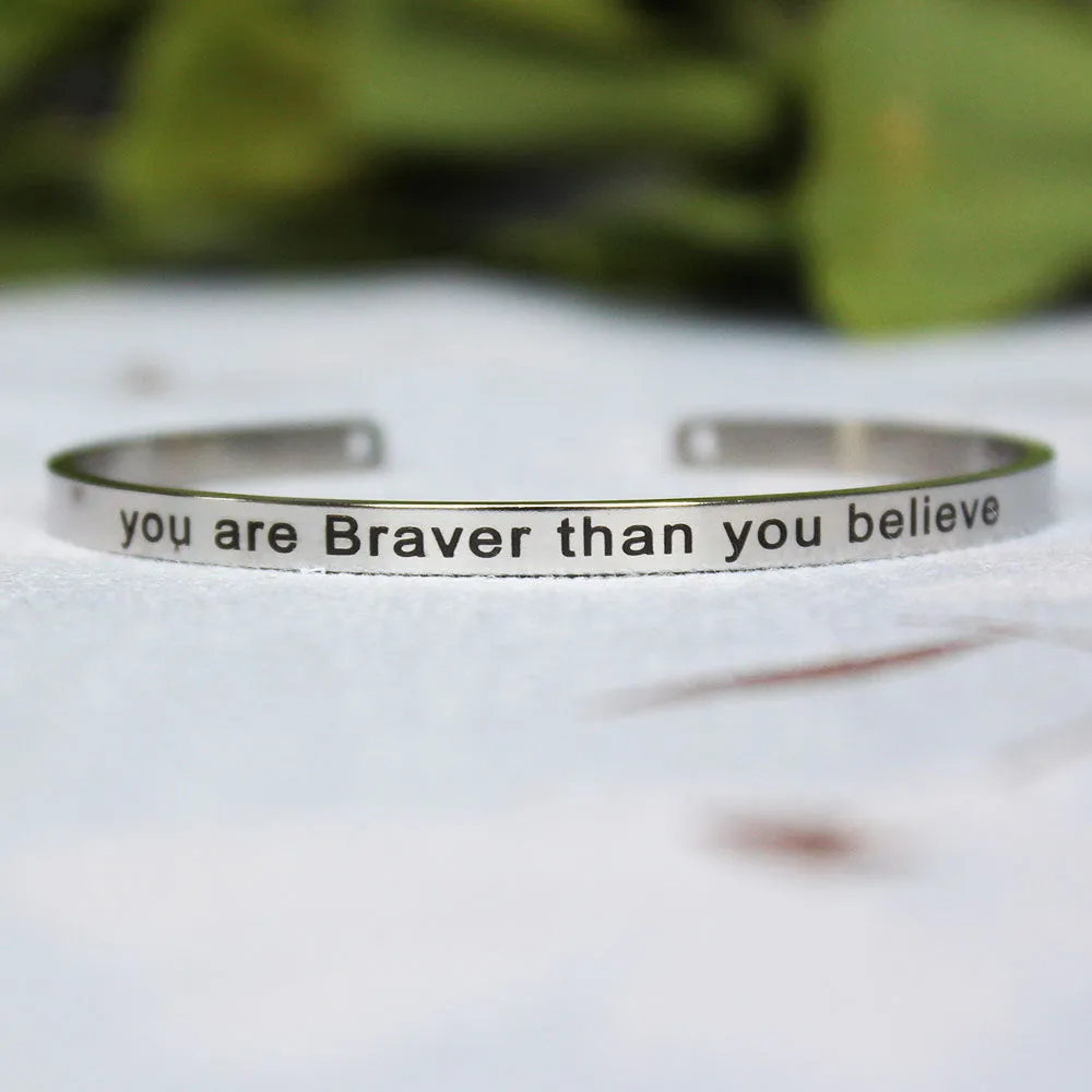 Silver customisable stainless steel bracelet with laser engraved text and adjustable fit on neutral background