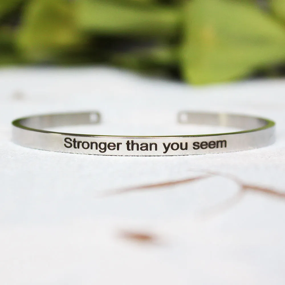 Silver customisable stainless steel bracelet with laser engraved text and adjustable fit on neutral background