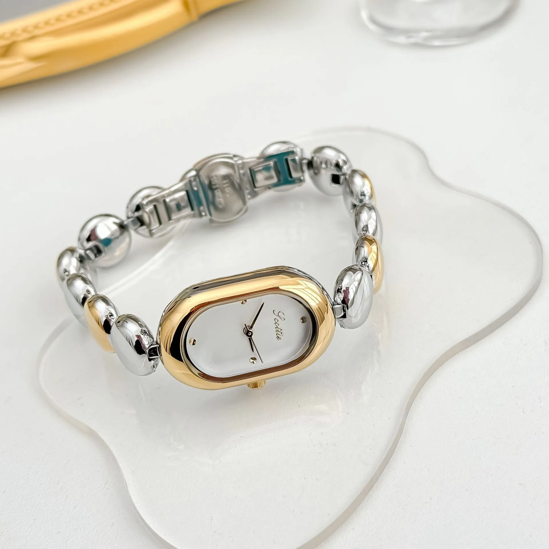 Women's oval gold tone watch with bracelet and 9mm case thickness