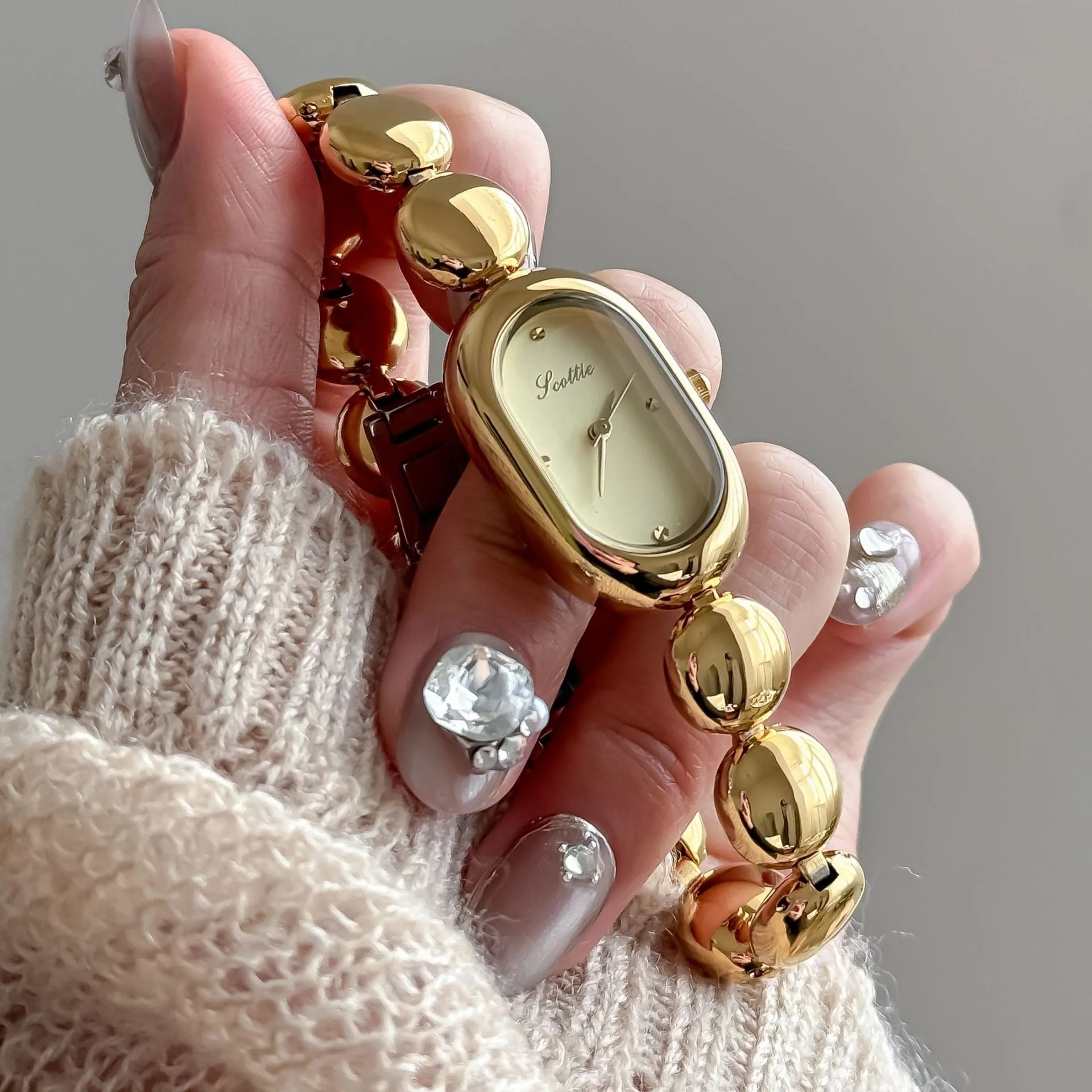 Women's oval gold tone watch with bracelet and 9mm case thickness
