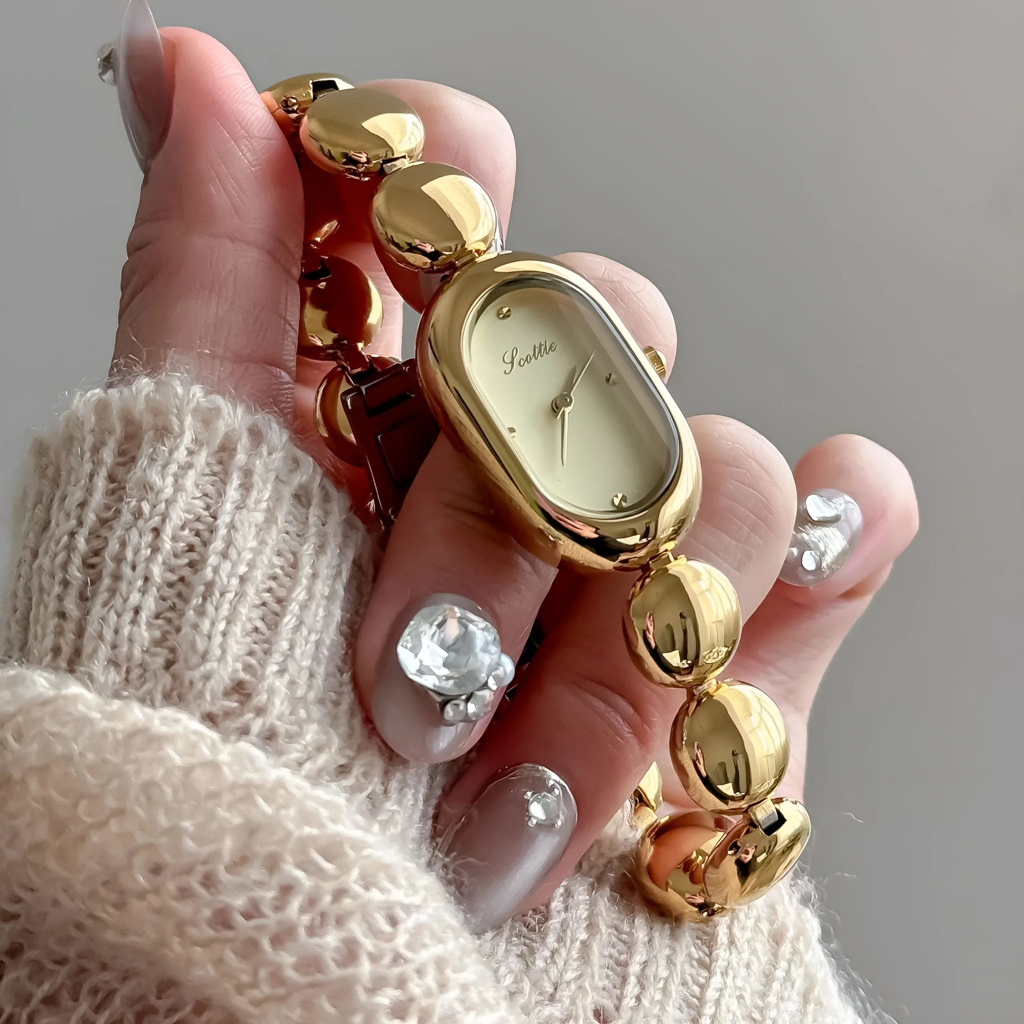 Women's oval gold tone watch with bracelet and 9mm case thickness