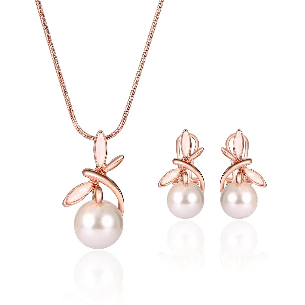 Rose gold alloy necklace with artificial gem pendant and matching earrings on a display surface