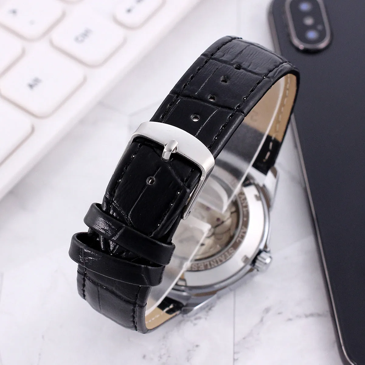 Men's transparent skeleton quartz watch with genuine leather strap on wrist, 37mm dial, alloy case, and stainless steel buckle