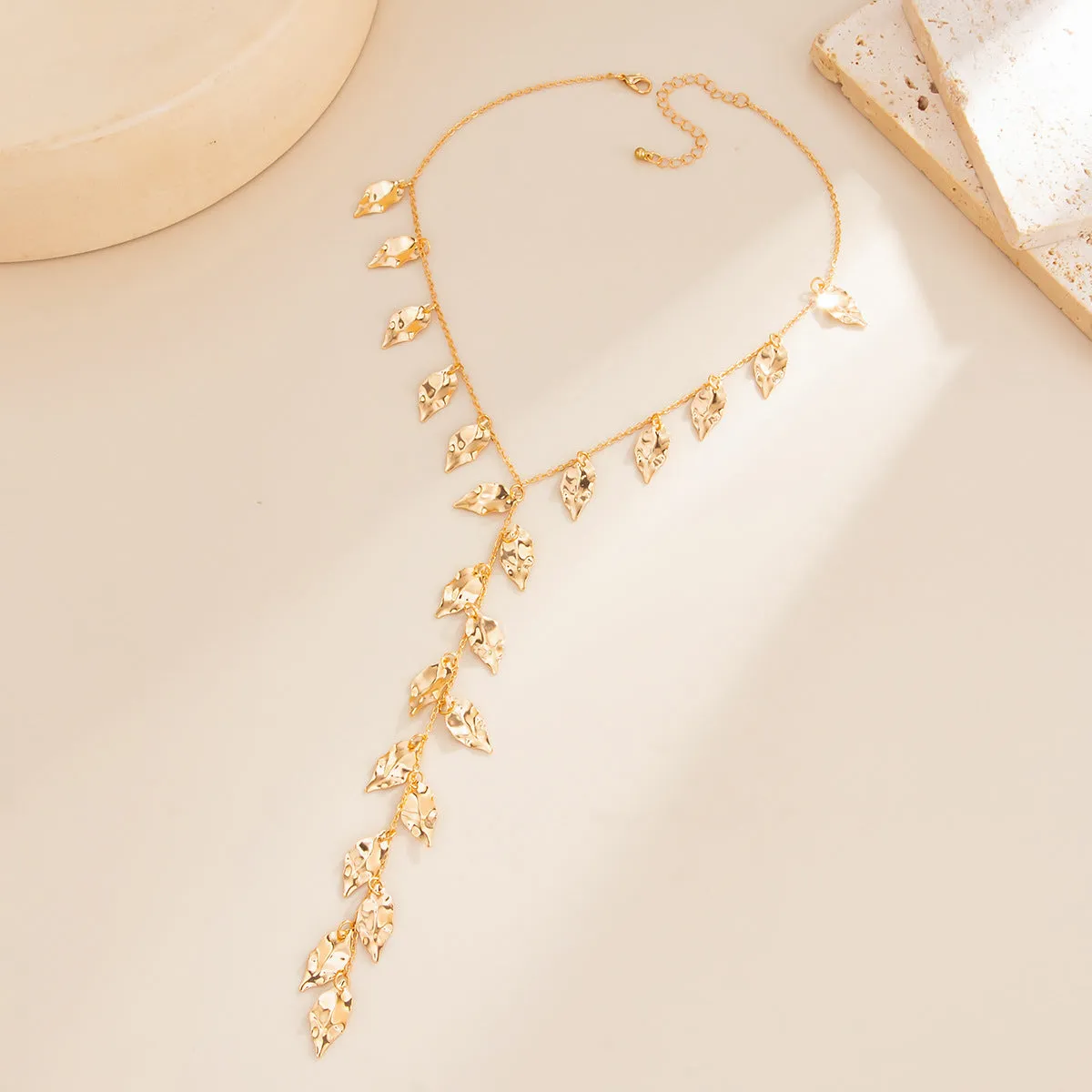 Y-shaped leaf fringe pendant necklace gold tone on white background, copper chain, iron leaf pendant