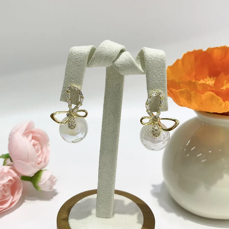 Pair of minimally designed gold tone drop earrings with single faux pearl