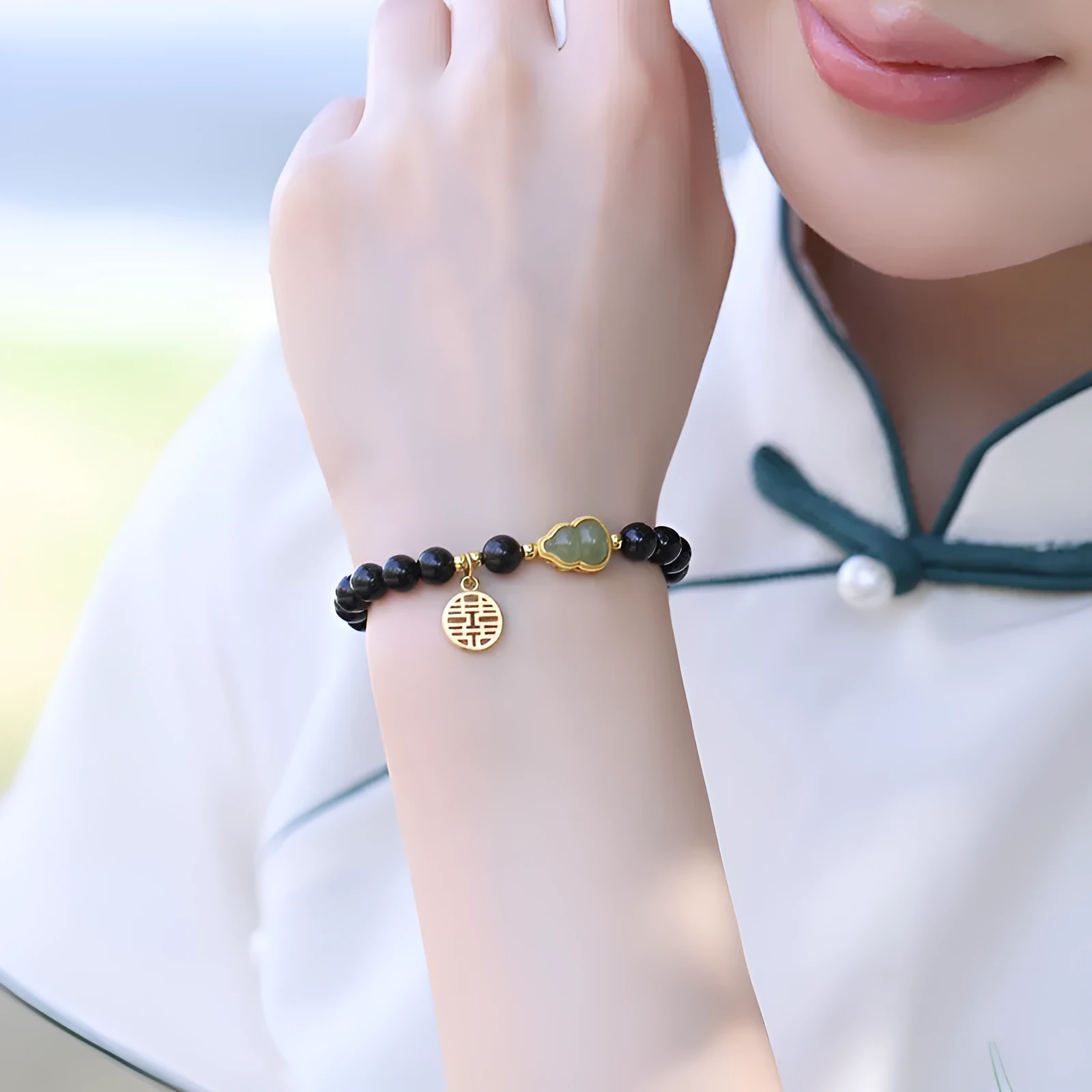 Black obsidian bracelet with a Hetian jade gourd charm in 10mm bead size.