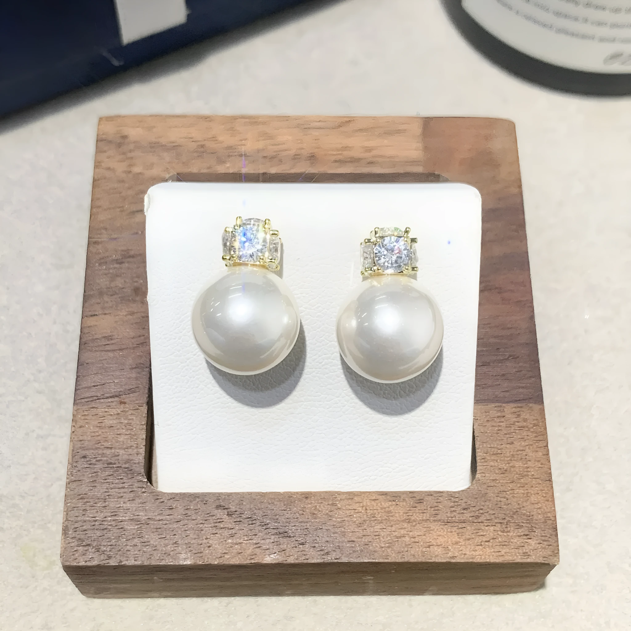 Simple zircon inlaid pearl earrings on display showing three style options