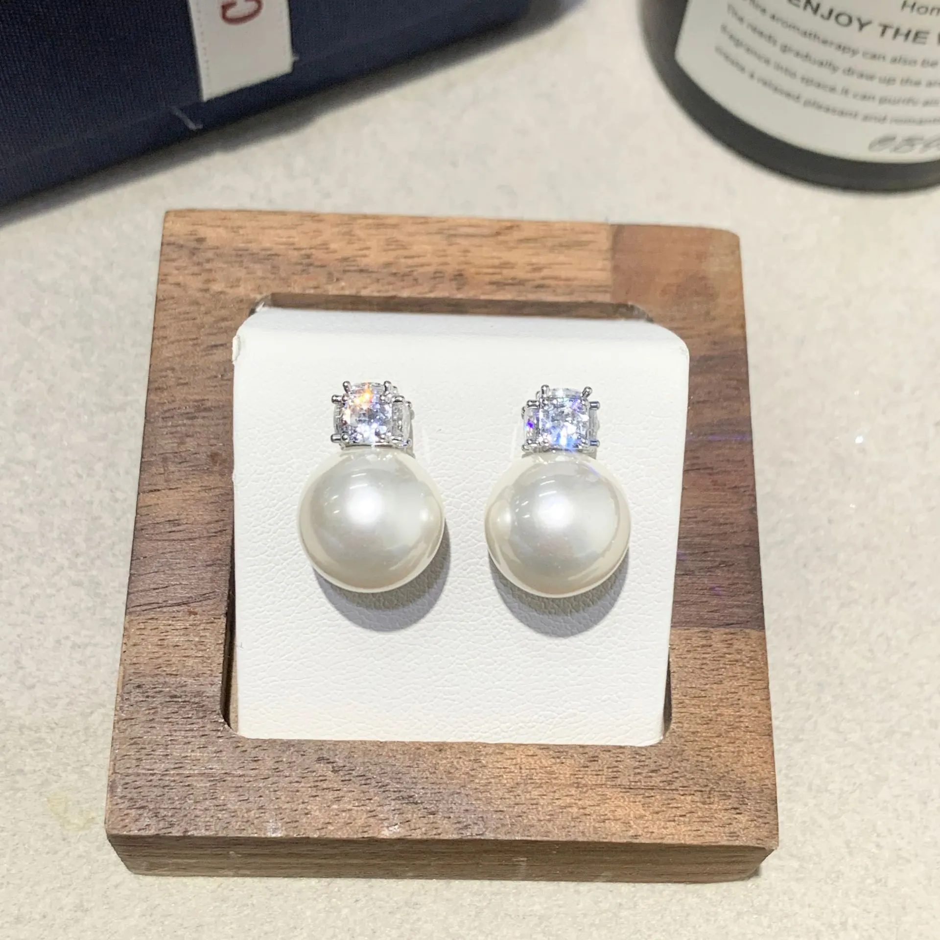 Simple zircon inlaid pearl earrings on display showing three style options