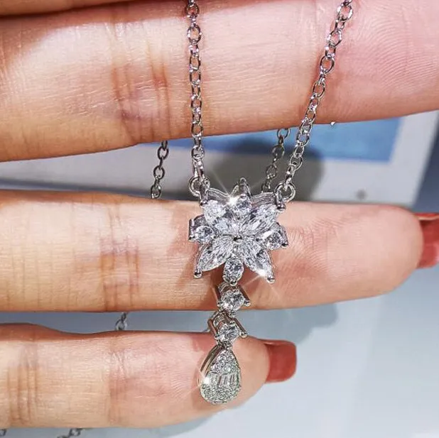 Floral zircon bridal jewellery set including ring, necklace with curb chain, and earrings on brass