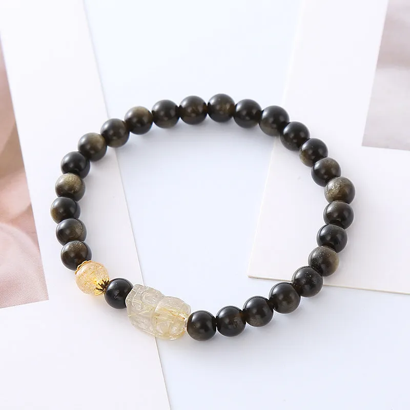 Handcrafted natural obsidian Pi Xiu bracelet with gold and red design on wrist