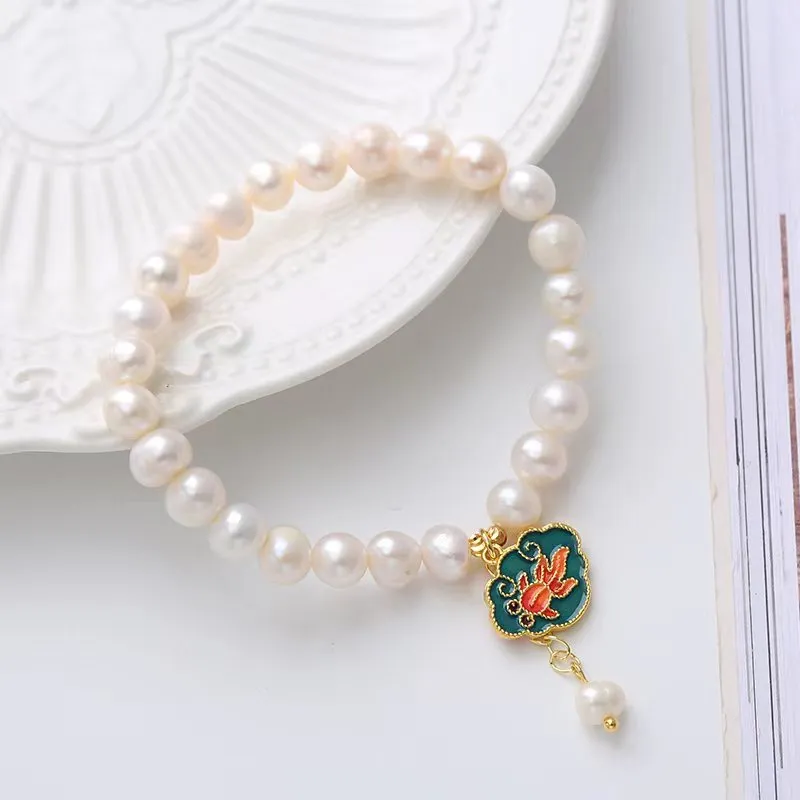 White vintage baroque bracelet with a freshwater pearl and goldfish lotus pendant.