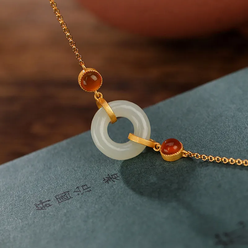 Gold-coloured women's bracelet with a silver base and an inlaid Hetian jade peace buckle charm.