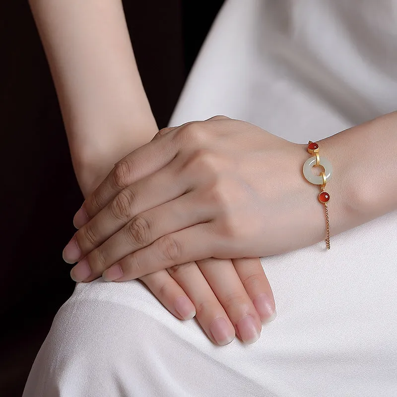 Gold-coloured women's bracelet with a silver base and an inlaid Hetian jade peace buckle charm.