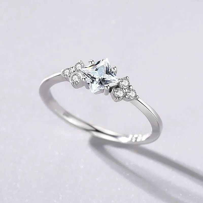 S925 silver ring with rhombus-shaped gold-plated setting and artificial gem on white background