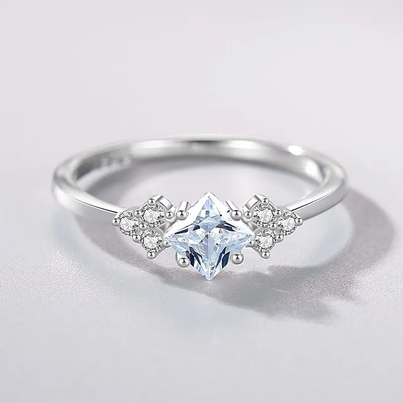 S925 silver ring with rhombus-shaped gold-plated setting and artificial gem on white background