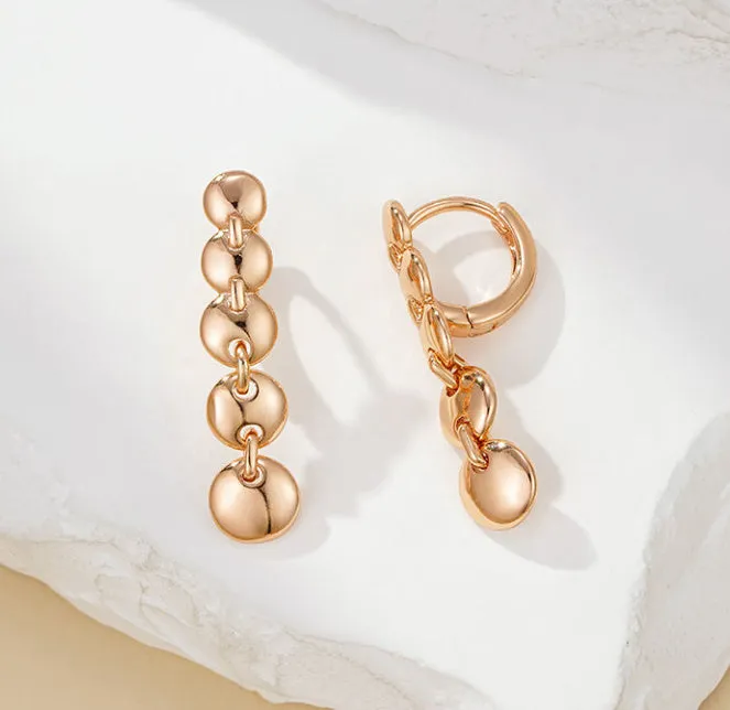 A pair of long, round circle-shaped retro earrings in a gold colour, made from woven copper