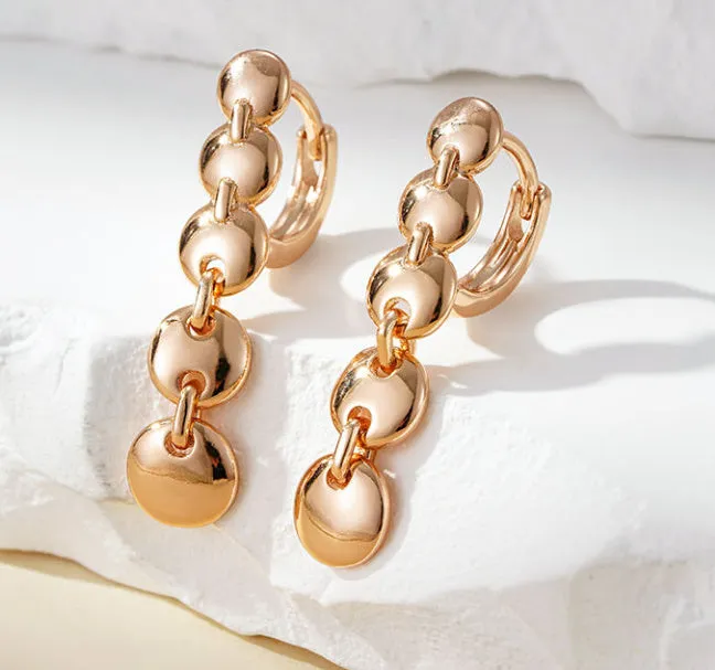 A pair of long, round circle-shaped retro earrings in a gold colour, made from woven copper