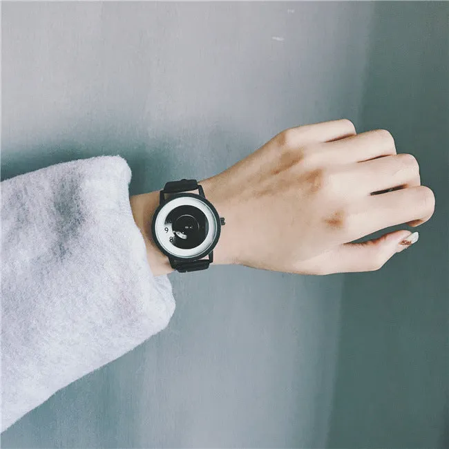 Casual unisex handless watch with pointer display, round dial, alloy case, and imitation leather strap on wrist