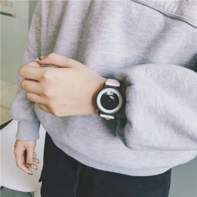 Casual unisex handless watch with pointer display, round dial, alloy case, and imitation leather strap on wrist