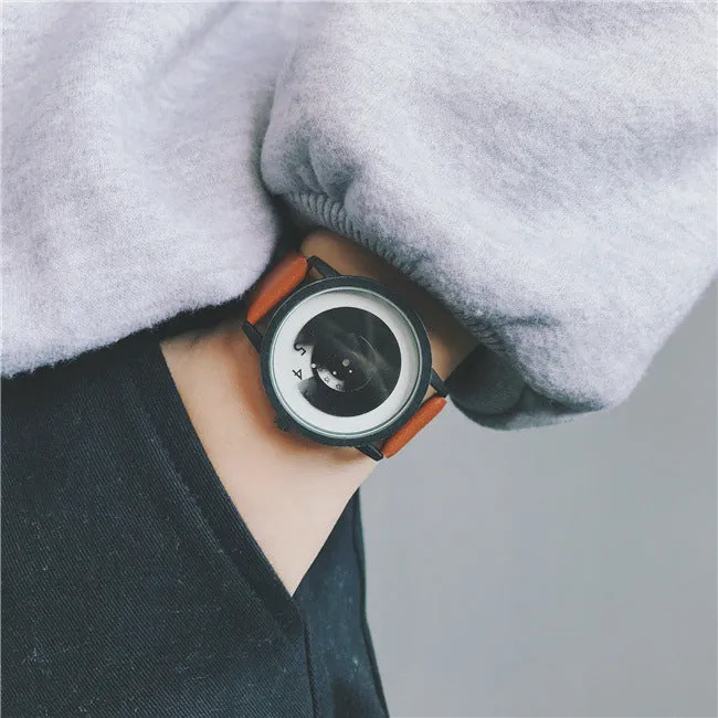 Casual unisex handless watch with pointer display, round dial, alloy case, and imitation leather strap on wrist