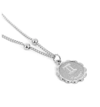 Gold plated metal zodiac constellation pendant necklace with bead chain on white background