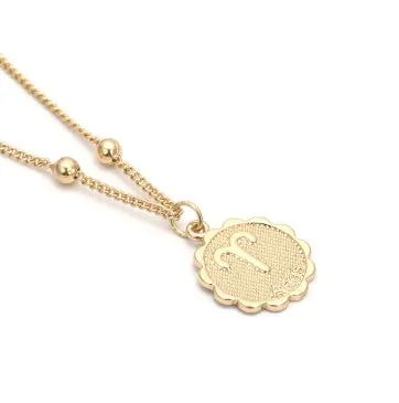 Gold plated metal zodiac constellation pendant necklace with bead chain on white background