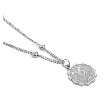 Gold plated metal zodiac constellation pendant necklace with bead chain on white background