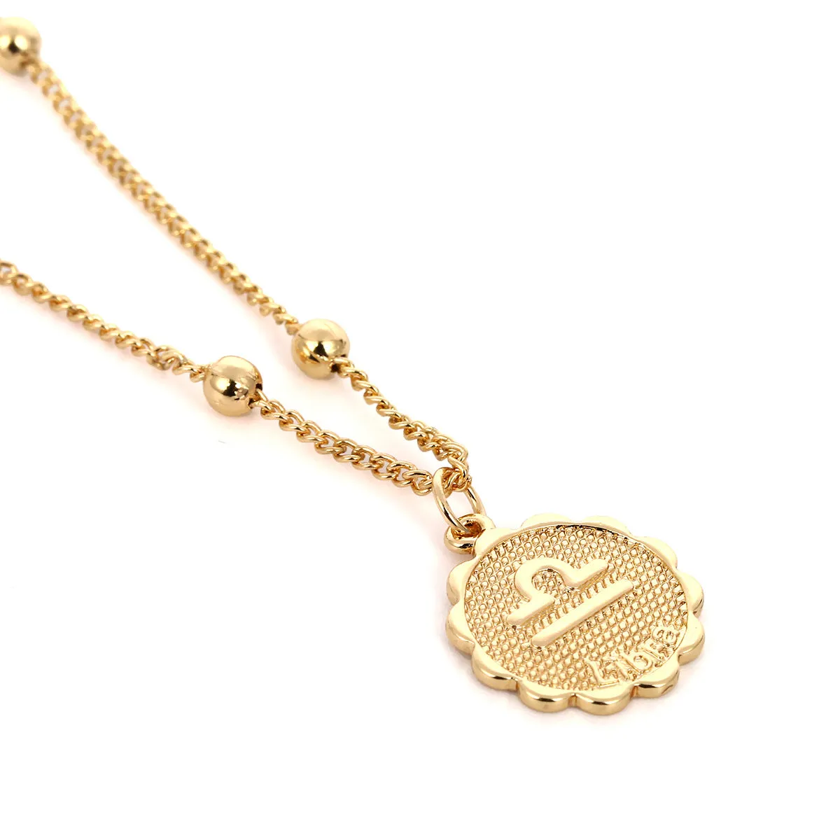 Gold plated metal zodiac constellation pendant necklace with bead chain on white background