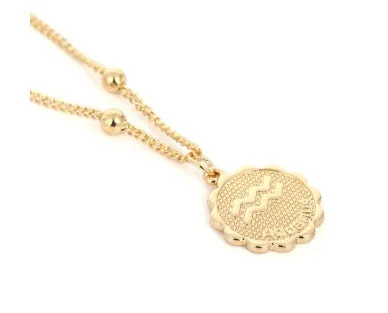 Gold plated metal zodiac constellation pendant necklace with bead chain on white background