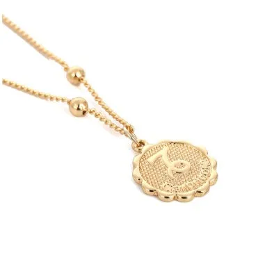Gold plated metal zodiac constellation pendant necklace with bead chain on white background