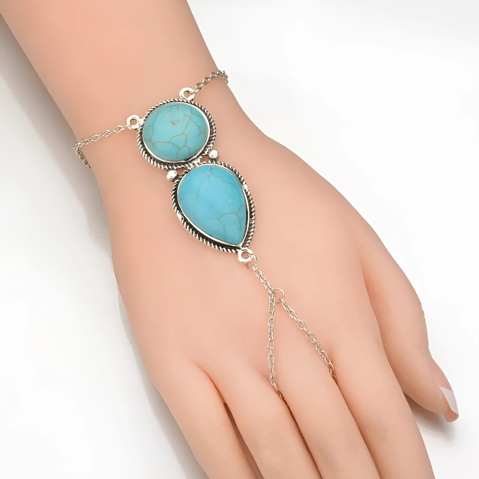 Silver alloy plated drop shape bracelet with turquoise tassel on a neutral background