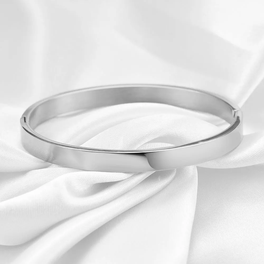 Polished stainless steel snap bracelet with oval links on plain background