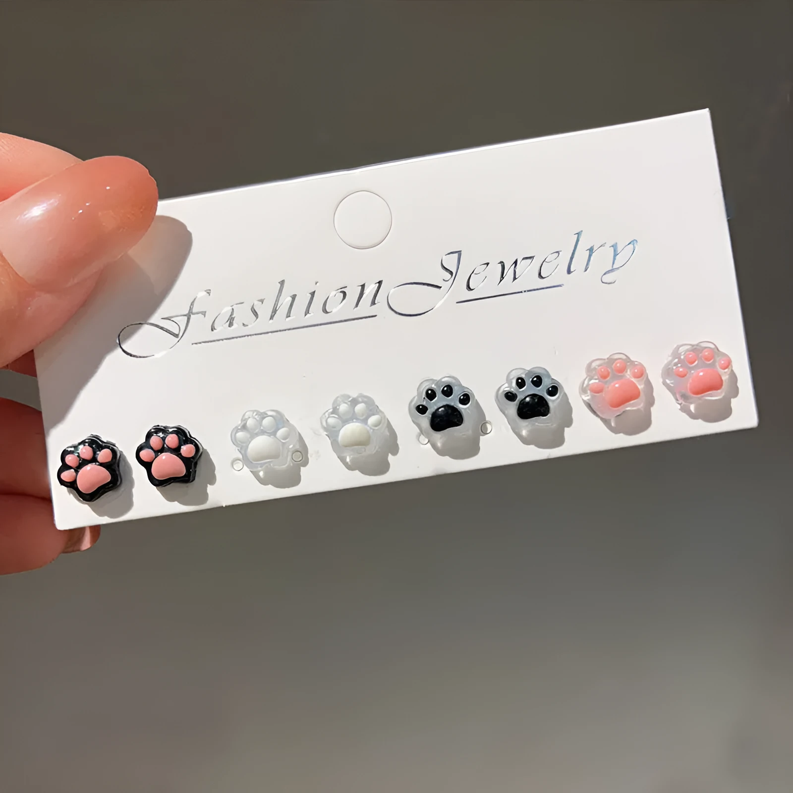 Cat paw magnetic ear clips in transparent pink colour with plastic resin finish, packaged as one pair